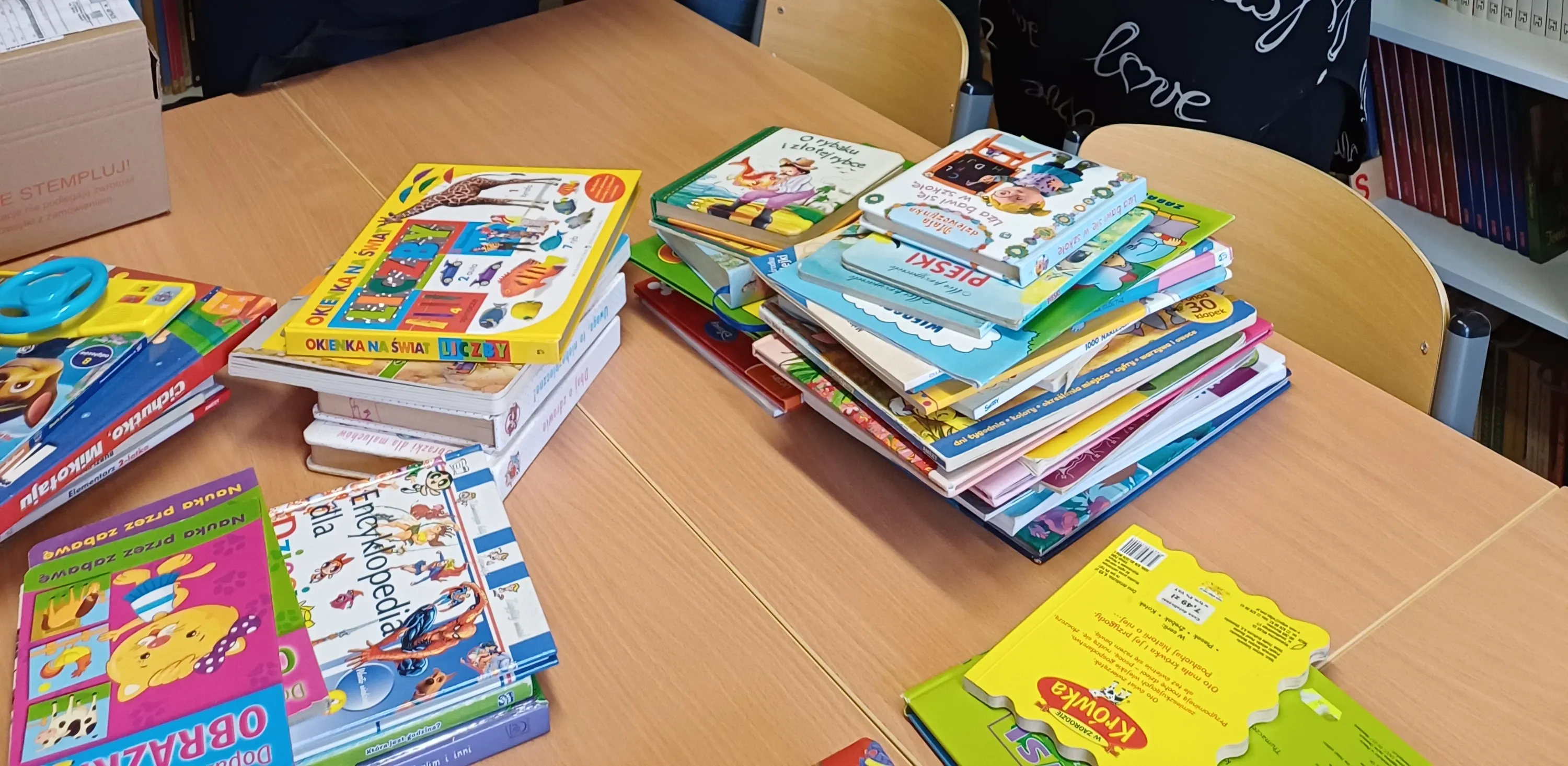 podarowane książki na stole w bibliotece