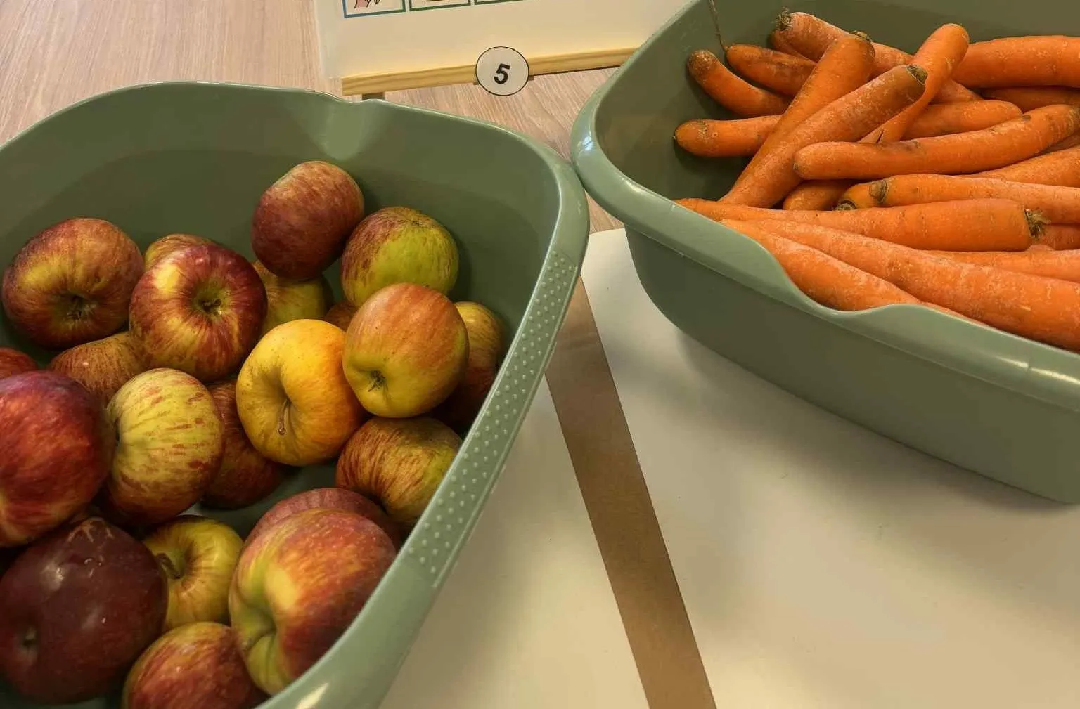 Na sole w miskach leżą pokrojone jabłka i marchewki