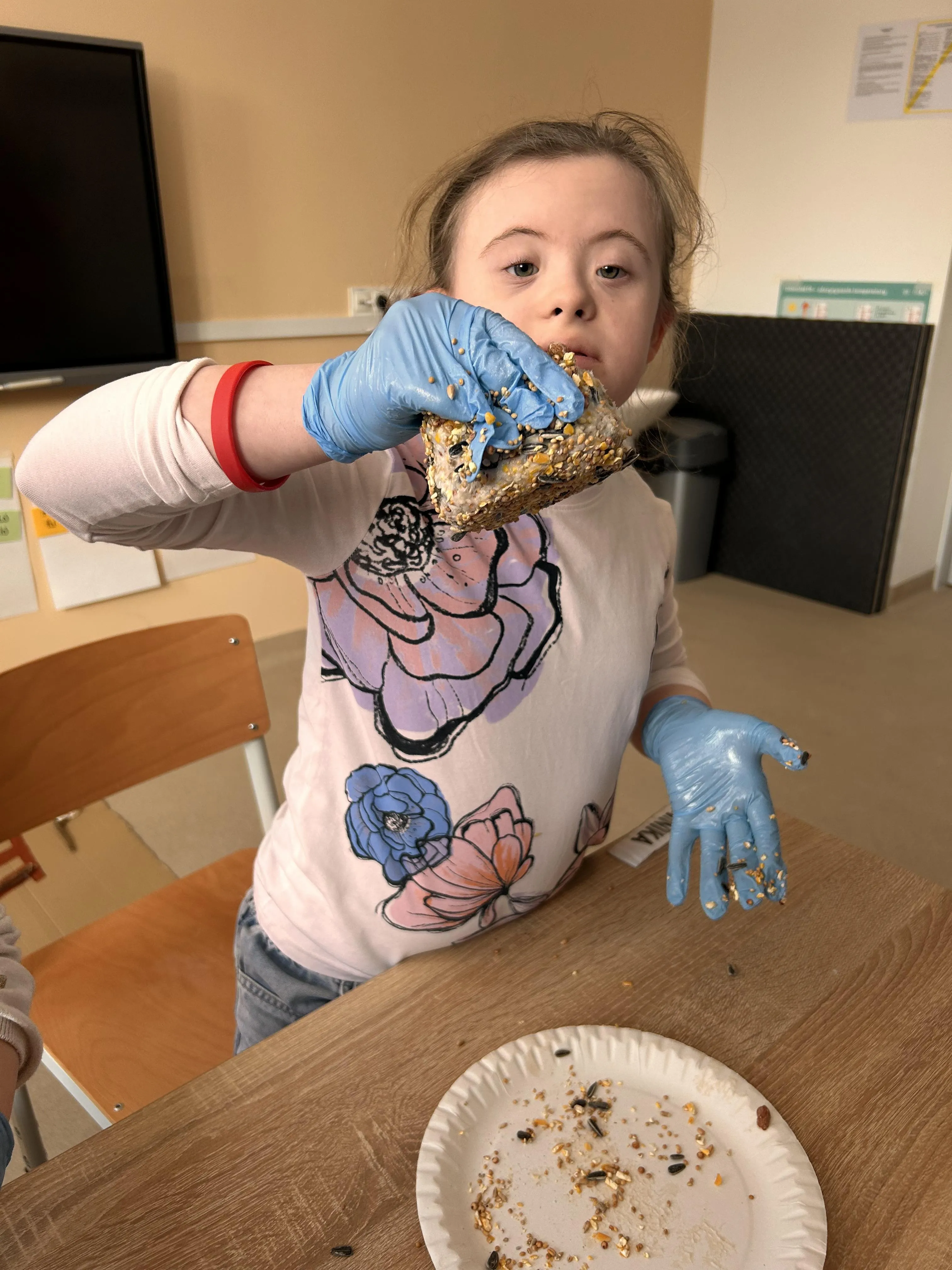 Uczennica prezentuje przygotowaną kulę pokarmową dla ptaków