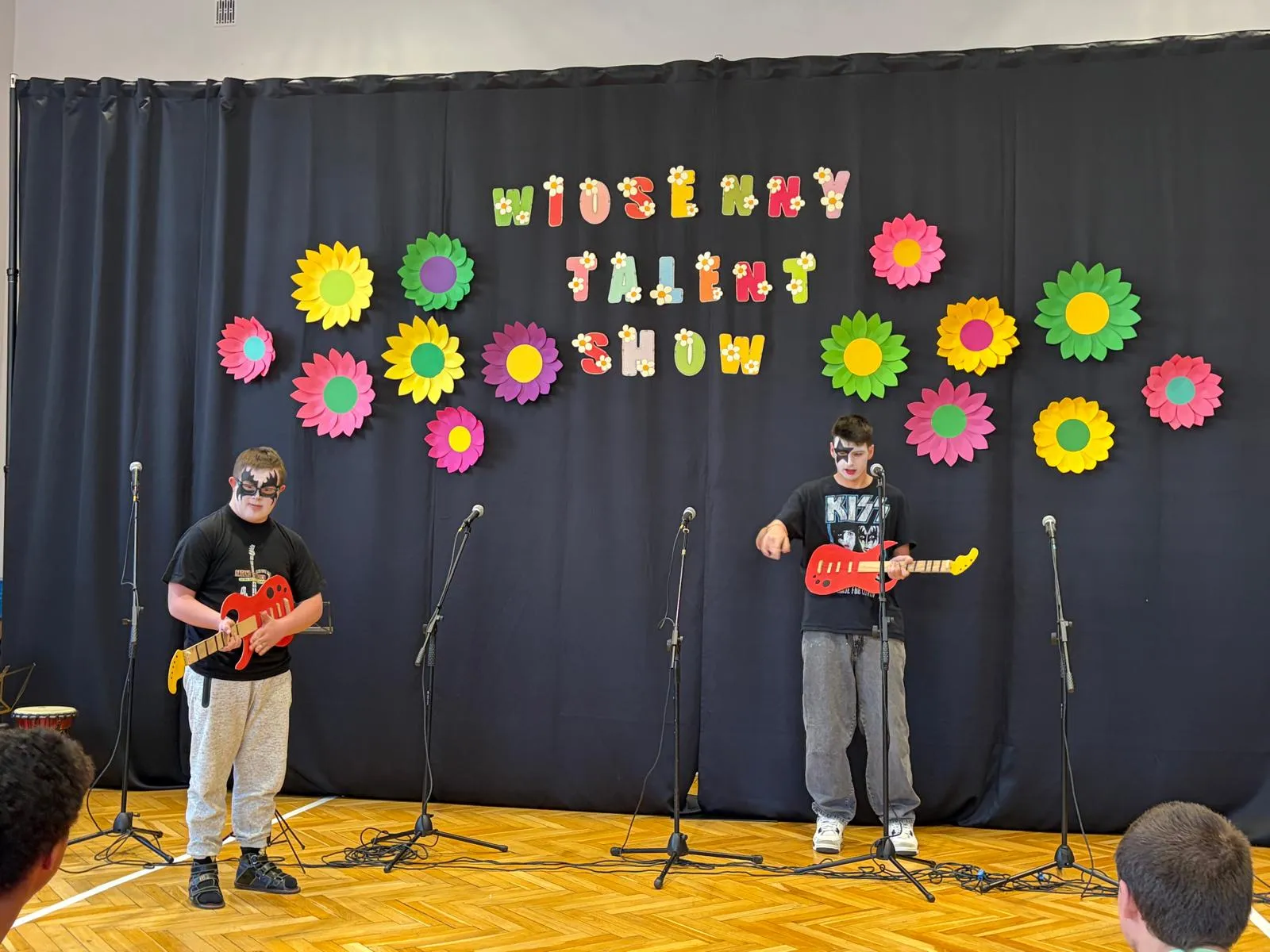 zdjecie przedstawia chłopców imitujacych gre na gitarach