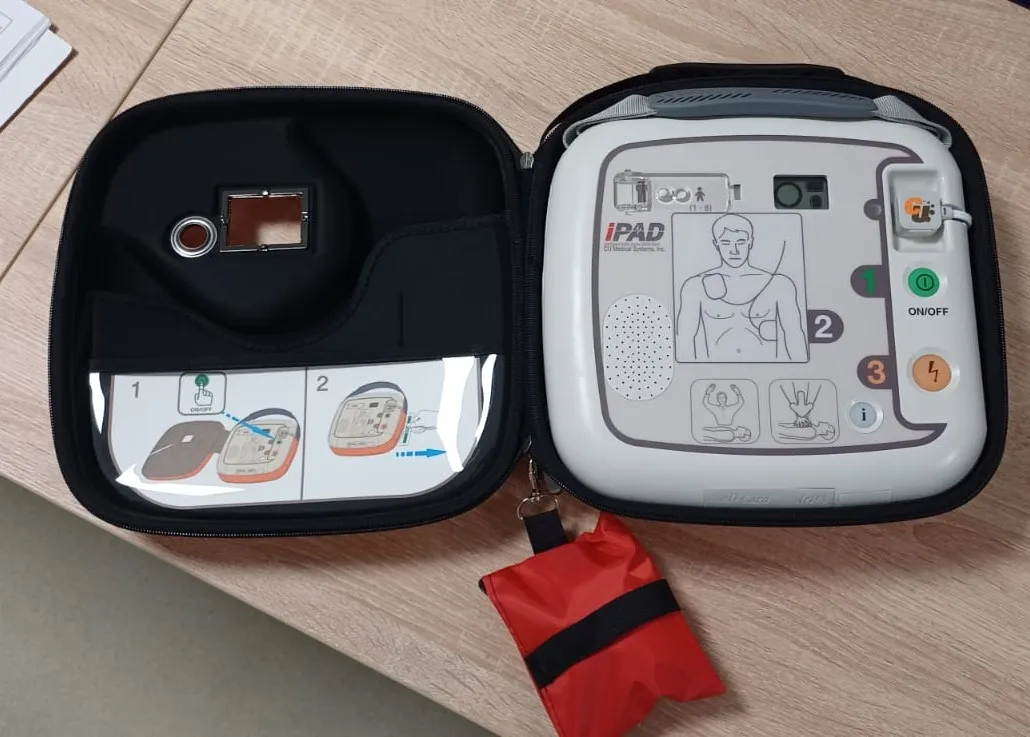 Zdjecie przedstawia otwartą torbę z urzadzeniem AED