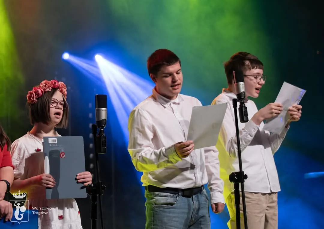 chłopcy i dziewczynka śpiewają na scenie 