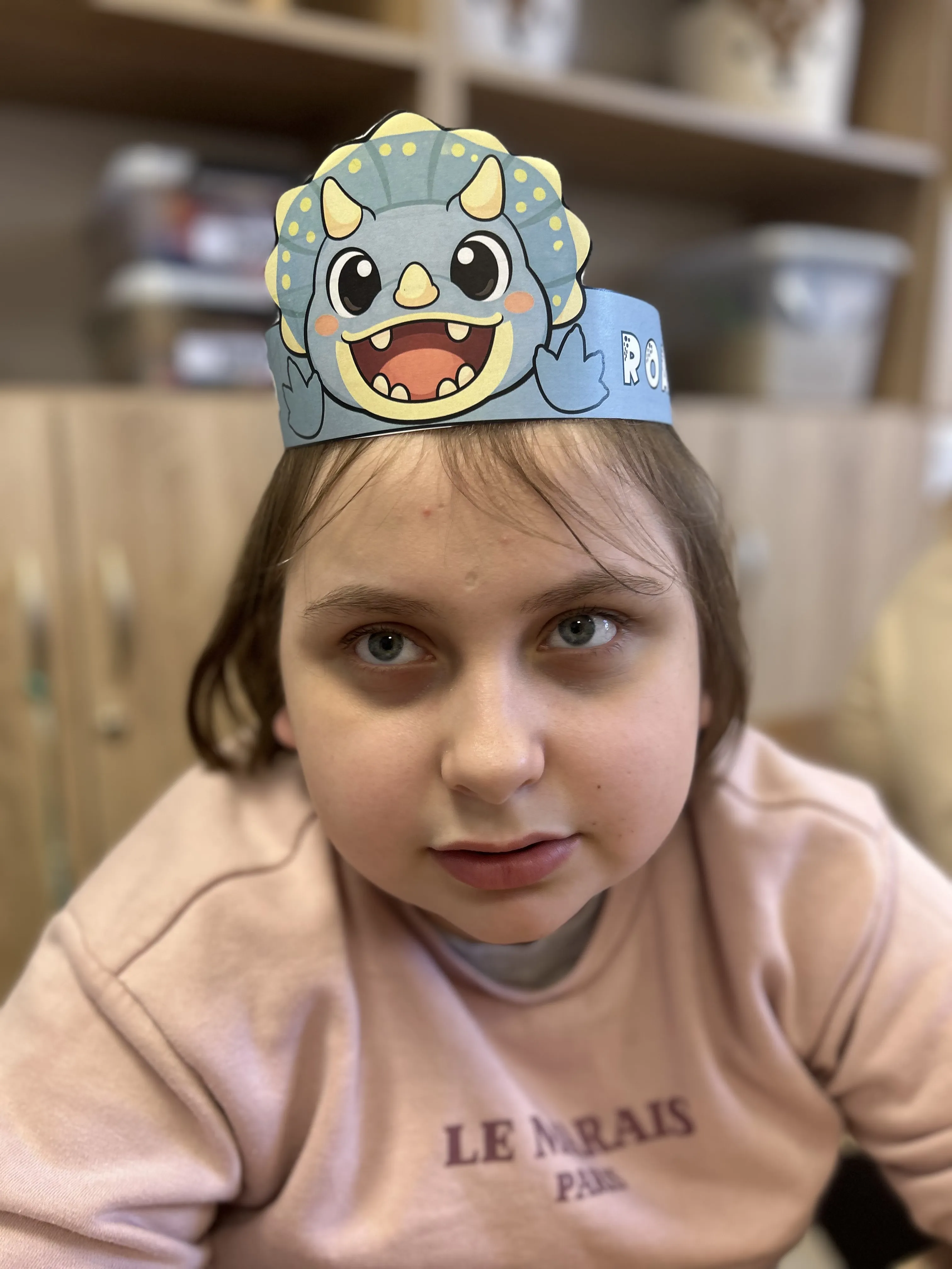 Zdjęcie uczennicy, która ma na głowie opaskę z dinozaurem
