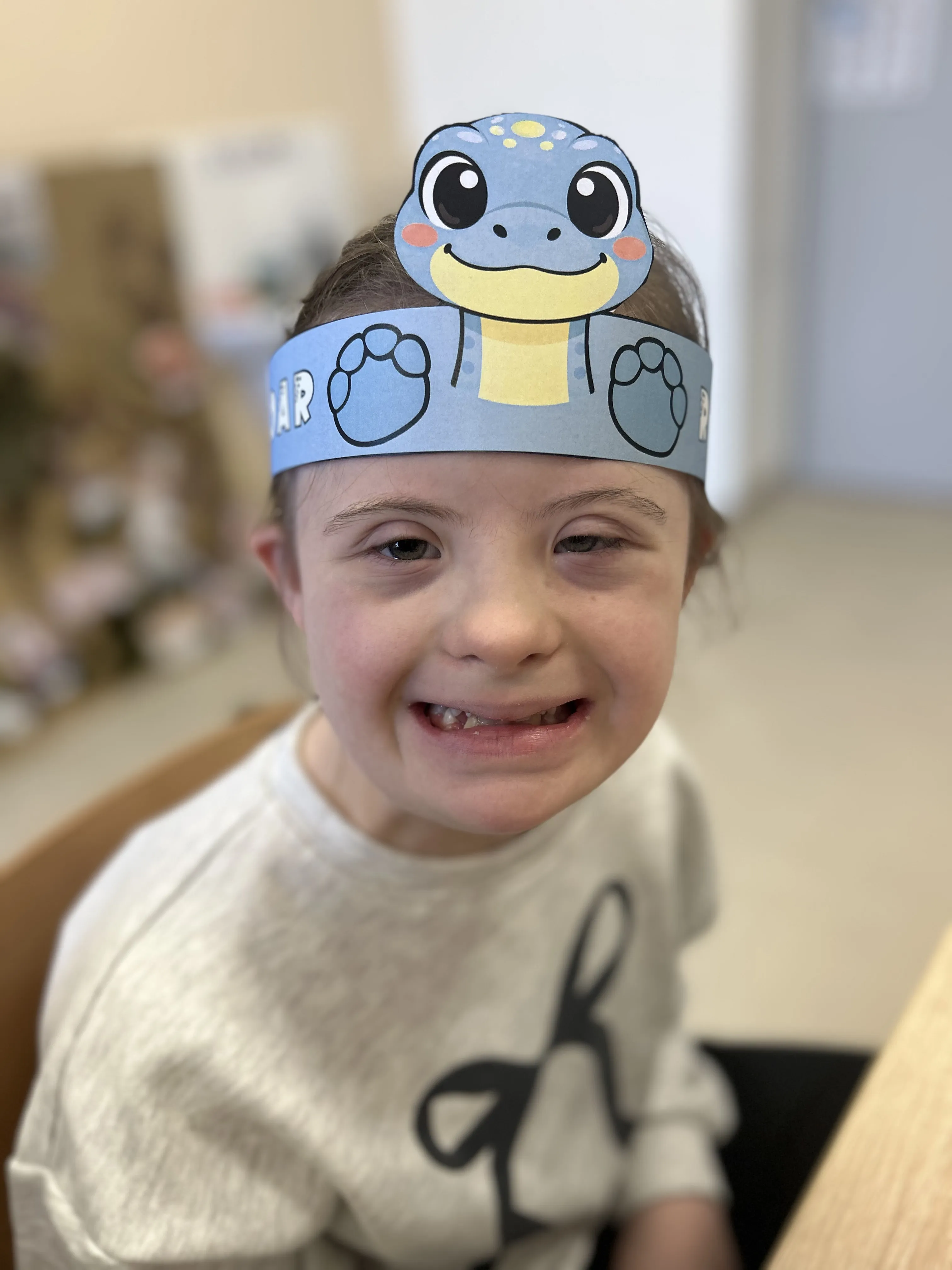 Zdjęcie uczennicy,  która ma na głowie opaskę z  dinozaurem