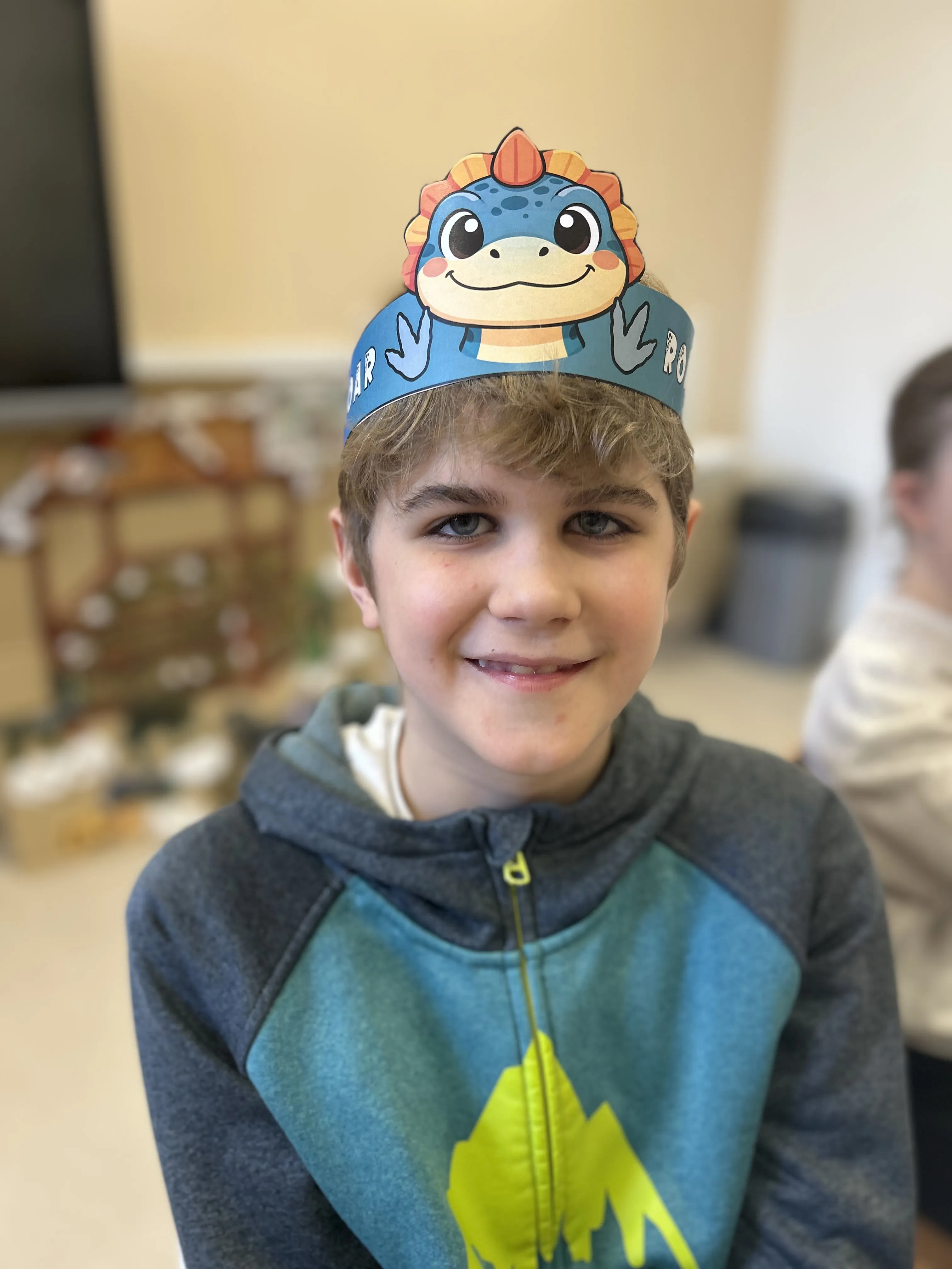 Zdjęcie uczenia, który ma na głowie opaskę z dinozaurem
