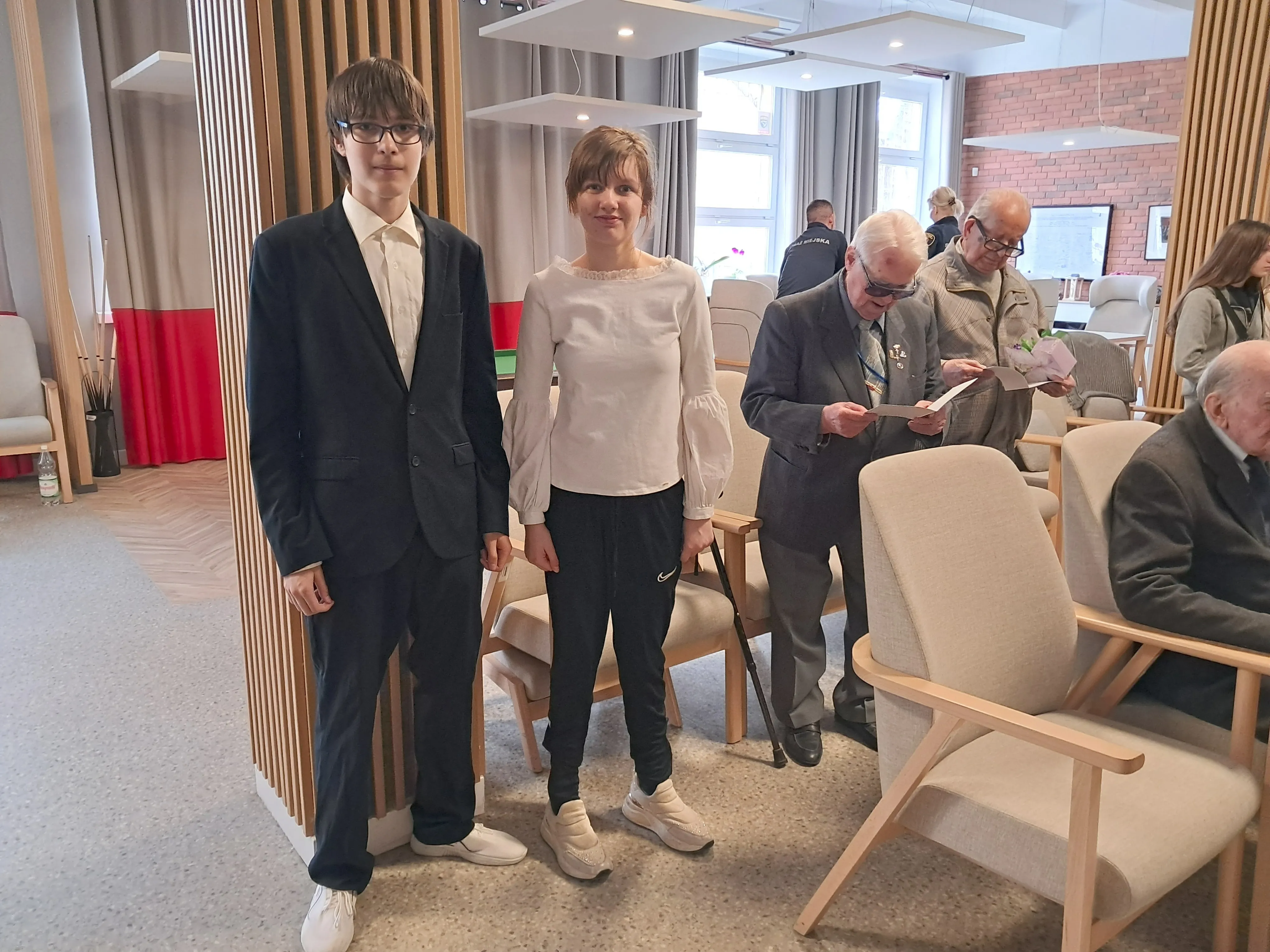 dwoje uczniów z klasy 7b w Domu Powstańców Warszawskich w towarzystwie  weteranów.