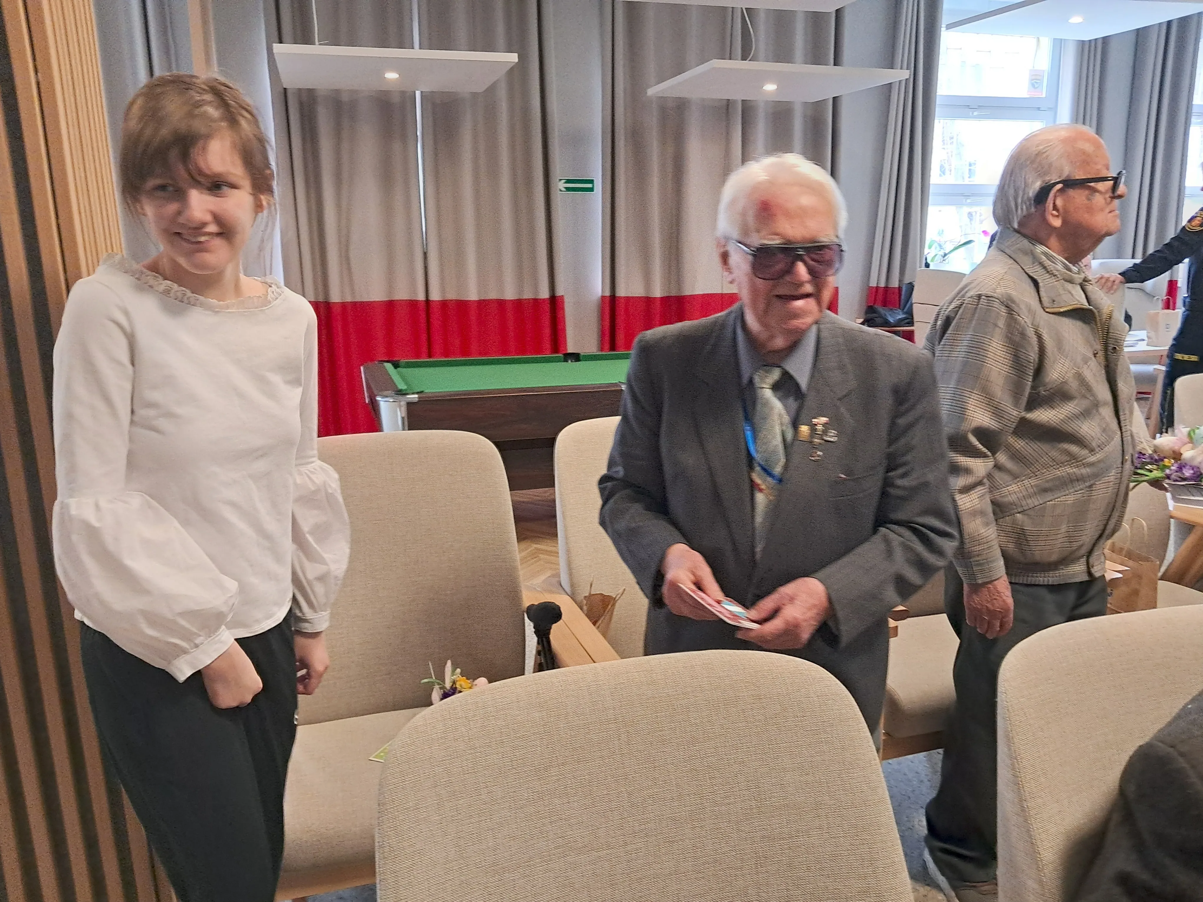 Uczennica z klasy 7b w Domu Powstańców Warszawskich w towarzystwie dwóch  weteranów.