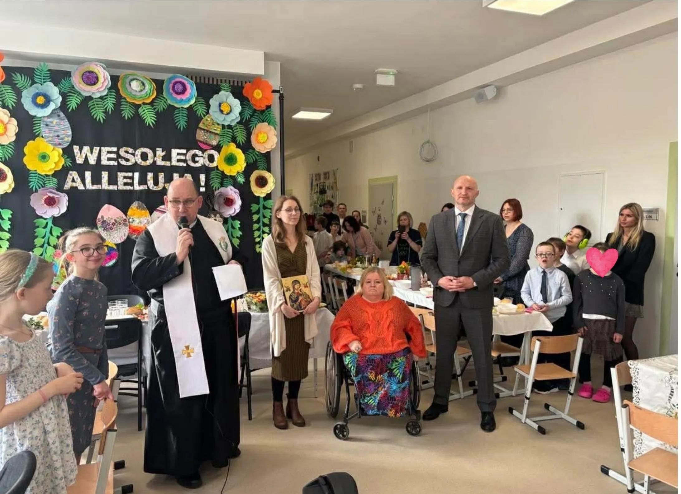 Ojciec Damian przemawiającyc do zebranych na szkolnym śniadaniu wielkanocnym na żytniej