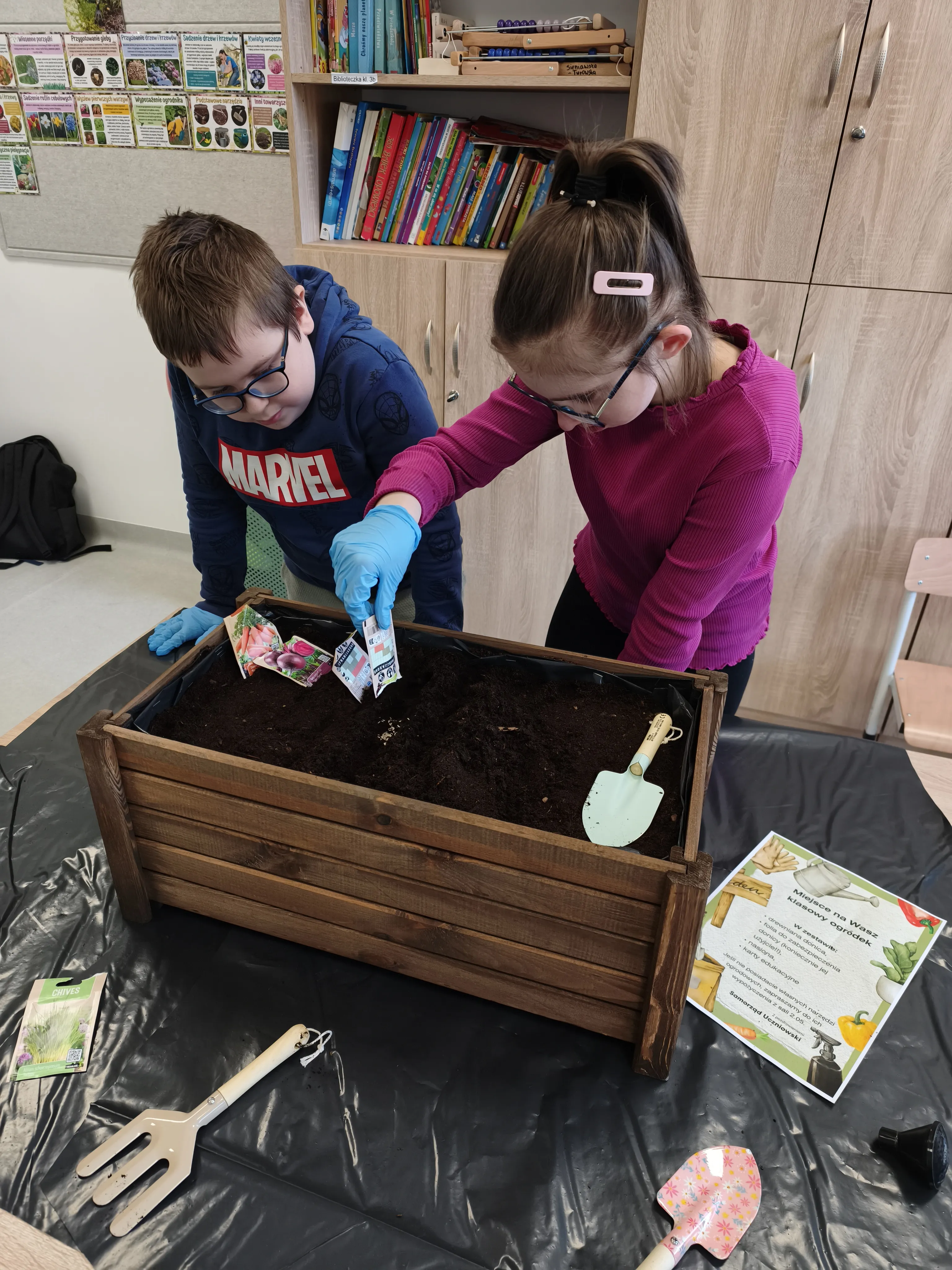 dziewczynka i chłopiec wspytuja ziemie do donic