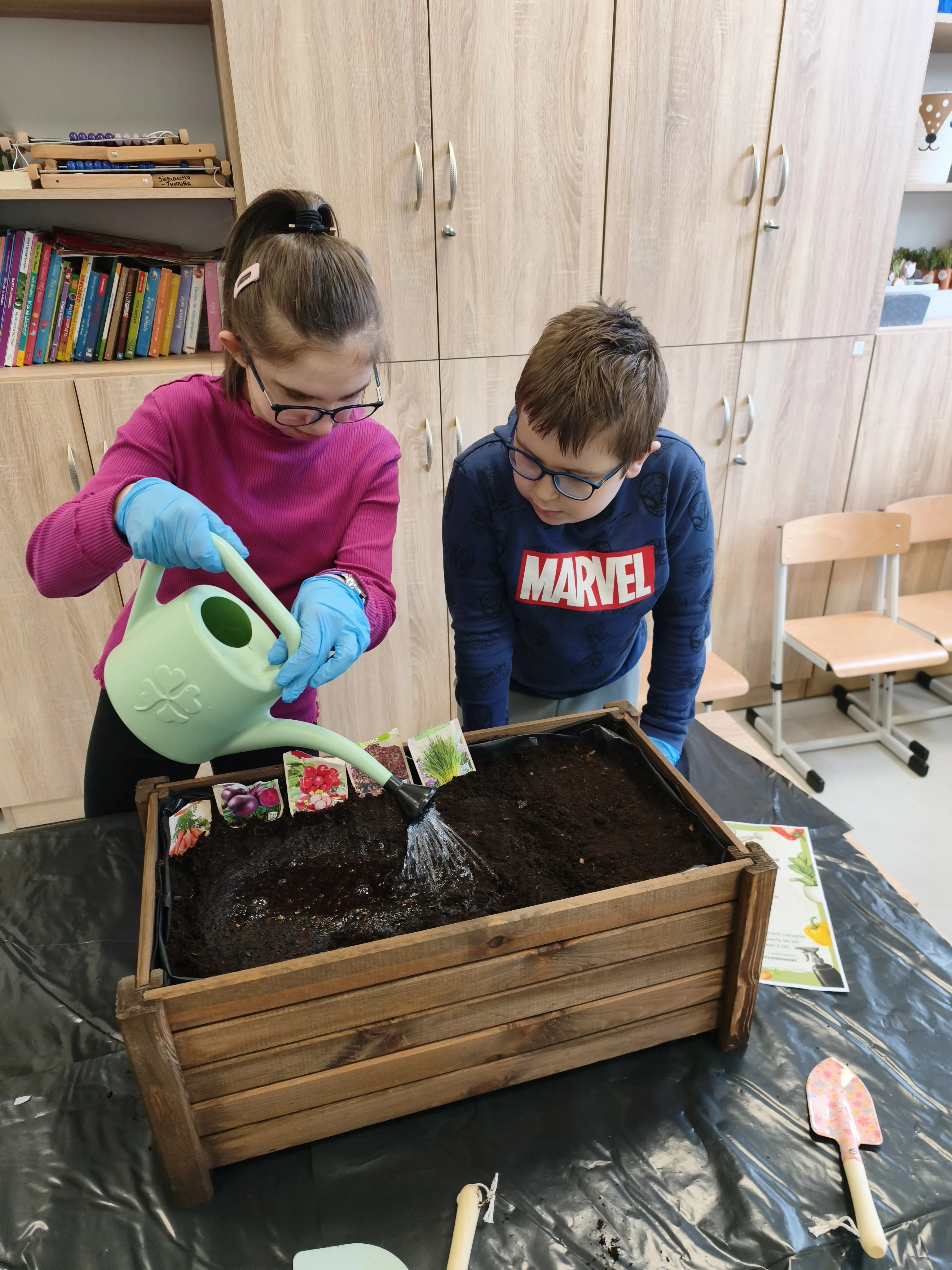 dziewczynka i chłopiec wspytuja ziemie do donic