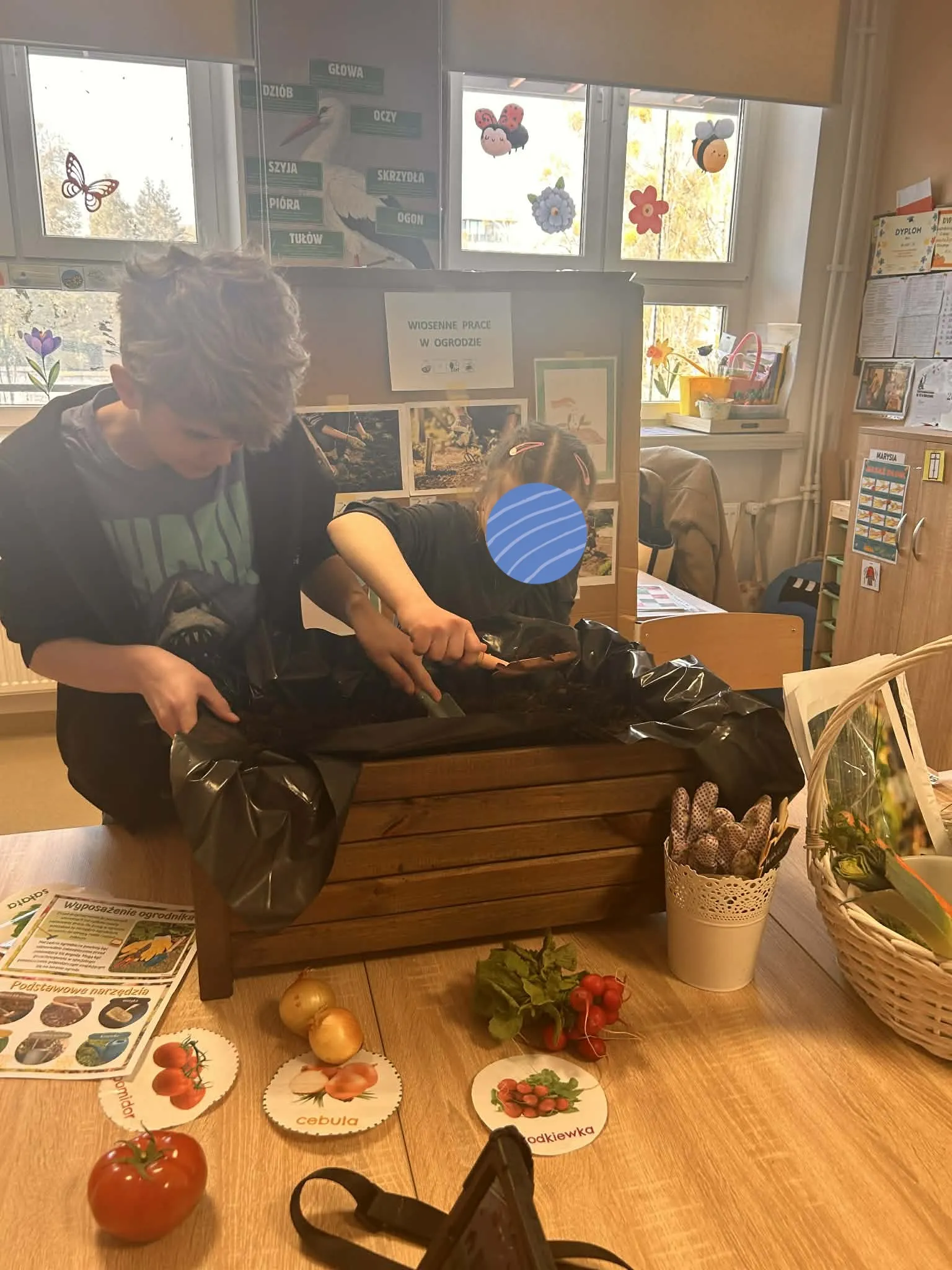 chłopiec i dziewczynka sadzą rośliny