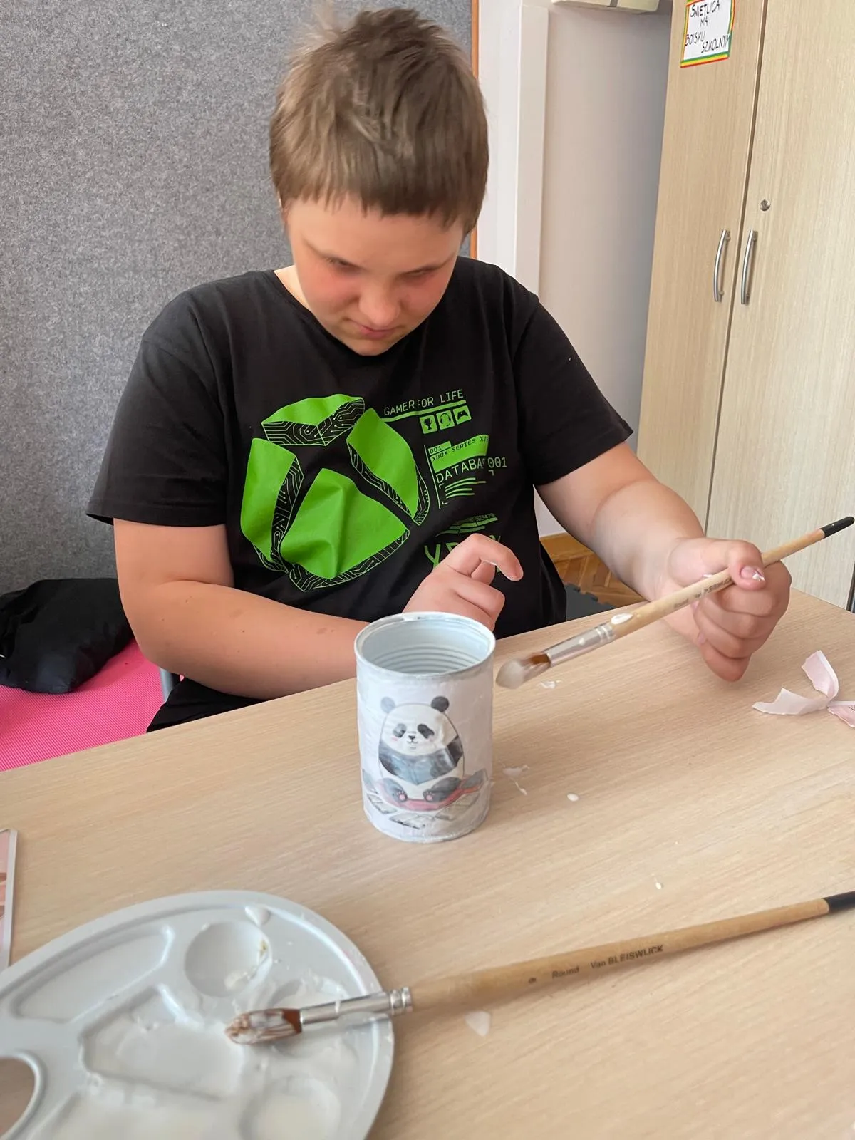 chłopiec maluje puszkę