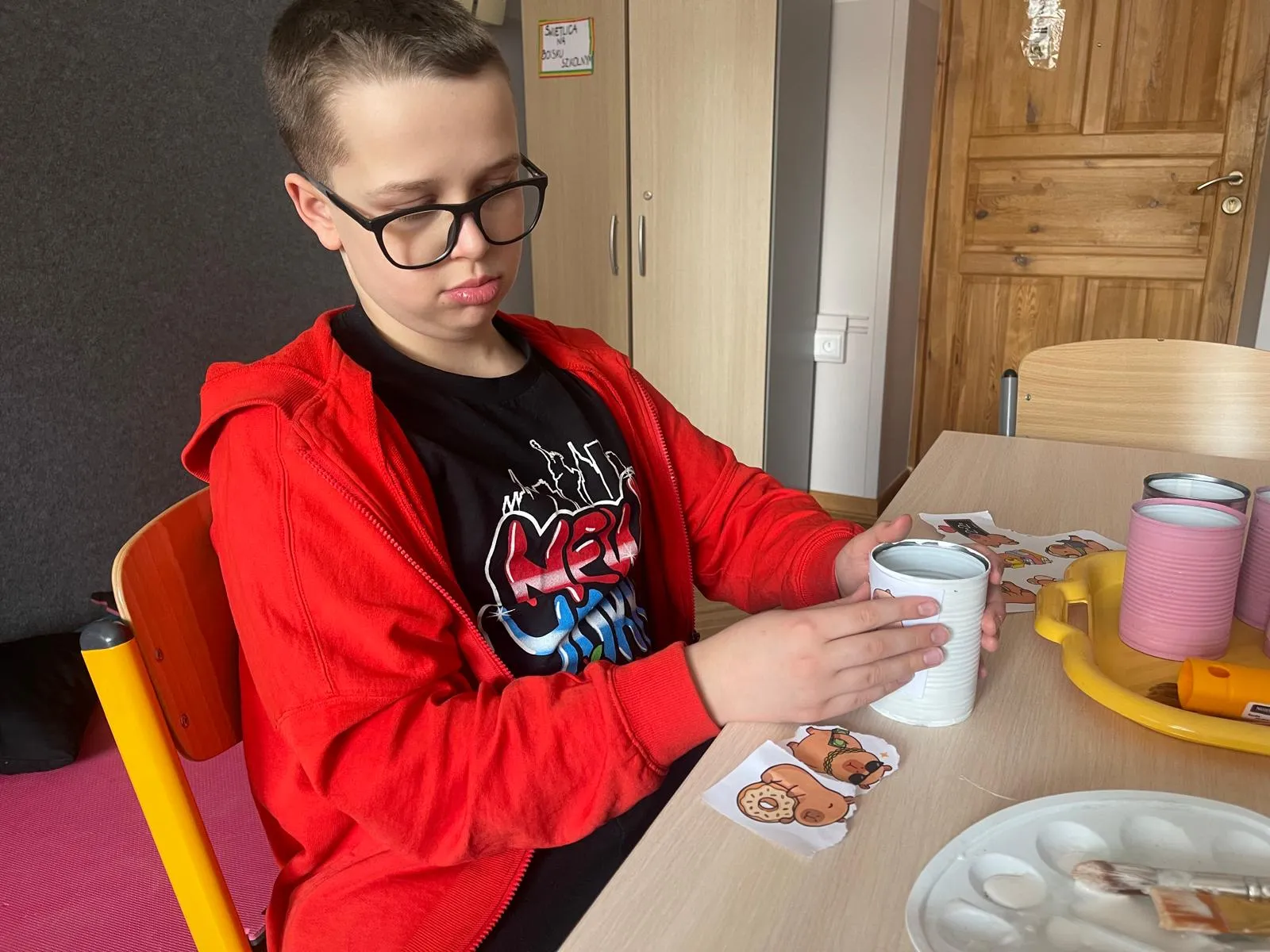 chłopiec wykleja puszkę