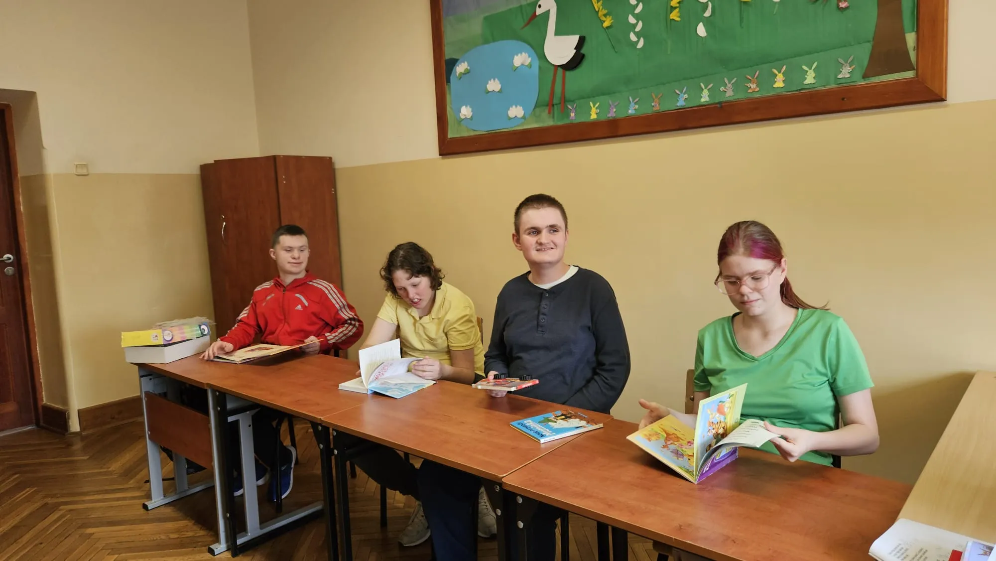 uczniowie w ławkach pochylają sie ksiazkami