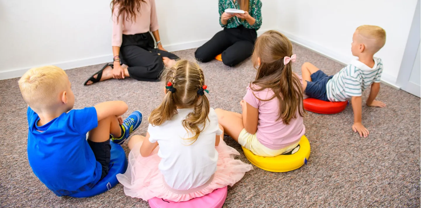 dzieci siedzace w kole