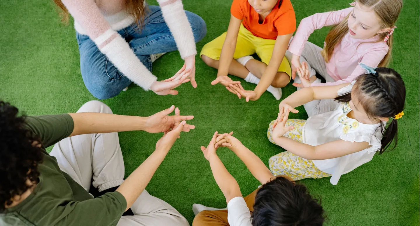 dzieci siedzace w kole