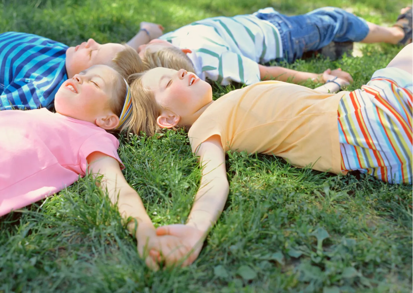 dzieci leżca na trawie